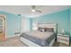 Bedroom showcasing a queen bed, ensuite, ceiling fan, and ample natural light streaming in from the exterior at 1675 Eden Ct, Clearwater, FL 33756