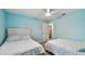 Comfortable bedroom featuring two twin beds, ceiling fan, and doorway to another room in the home at 1675 Eden Ct, Clearwater, FL 33756