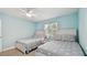 Inviting bedroom featuring two comfortable twin beds, a ceiling fan, and a window with pleasant outdoor views at 1675 Eden Ct, Clearwater, FL 33756