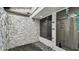 Outdoor patio with rock flooring and stone wall showing a glass enclosed bathroom and shower at 1675 Eden Ct, Clearwater, FL 33756