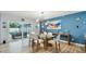 Dining room with modern lighting fixture and seating for six, adjacent to the pool area at 1675 Eden Ct, Clearwater, FL 33756