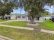 Traditional single-story home with a well-manicured lawn, mature trees, and inviting curb appeal at 1675 Eden Ct, Clearwater, FL 33756