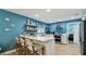 Bright kitchen boasts white cabinets, stainless steel appliances, breakfast bar and beachy décor at 1675 Eden Ct, Clearwater, FL 33756