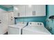 Functional laundry area features appliances and storage cabinets, optimizing space at 1675 Eden Ct, Clearwater, FL 33756