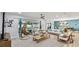 Open-concept living room with modern furniture, a hanging chair, and views of the pool area at 1675 Eden Ct, Clearwater, FL 33756
