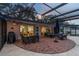 Beautiful brick outdoor patio with screened-in enclosure features dining and seating areas for entertainment and relaxation at 1675 Eden Ct, Clearwater, FL 33756