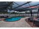 Screened in pool and patio with nearby hot tub and plentiful seating makes for a perfect entertaining space at 1675 Eden Ct, Clearwater, FL 33756