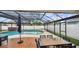 Relaxing screened pool and patio area with hot tub, ample seating, and dining space under a trellis at 1675 Eden Ct, Clearwater, FL 33756