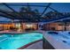 Inviting screened-in pool area with in-ground pool, hot tub and patio space at 1675 Eden Ct, Clearwater, FL 33756