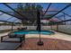 Inviting pool and patio area with lounge seating, umbrella and nearby hot tub under a screened enclosure at 1675 Eden Ct, Clearwater, FL 33756