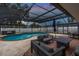 Outdoor oasis with sparkling pool, cozy seating, and a relaxing hot tub all under a screened enclosure at 1675 Eden Ct, Clearwater, FL 33756