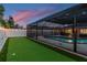 A backyard putting green with string lights along the fence offers a relaxing and fun outdoor space at 1675 Eden Ct, Clearwater, FL 33756
