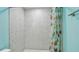Modern shower stall with unique white-patterned tilework and decorative floral shower curtain at 1675 Eden Ct, Clearwater, FL 33756