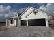 Modern two-story home featuring black garage doors and a paved driveway at 18033 Foxtail Loop, Venice, FL 34293