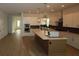 Modern kitchen boasts stainless steel appliances, a large island with stone countertops, and open access to living areas at 18033 Foxtail Loop, Venice, FL 34293