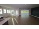 Open floor plan combining a living room and dining area with views of the pool and backyard through sliding doors at 18033 Foxtail Loop, Venice, FL 34293