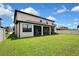 A spacious backyard with a well-maintained lawn and a covered patio, ideal for outdoor activities at 1821 Cherry Walk Rd, Lutz, FL 33558