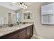 Bathroom features a double vanity with granite countertops and warm dark wood cabinetry at 1821 Cherry Walk Rd, Lutz, FL 33558