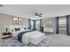 A stylish bedroom featuring a ceiling fan and a large bed with a bench at the end at 1821 Cherry Walk Rd, Lutz, FL 33558