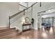 Bright foyer showcasing staircase with dark trim, hardwood floors, and a view of the living room at 1821 Cherry Walk Rd, Lutz, FL 33558
