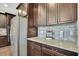 Spacious kitchen featuring stainless steel refrigerator, granite countertops, and dark cabinets at 1821 Cherry Walk Rd, Lutz, FL 33558