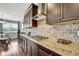 Well-equipped kitchen featuring stainless hood, granite countertops, and dark wood cabinets at 1821 Cherry Walk Rd, Lutz, FL 33558