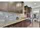 Well-appointed kitchen showcasing stainless steel hood, granite counters, and tile backsplash at 1821 Cherry Walk Rd, Lutz, FL 33558