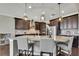 Beautiful kitchen features granite countertops, stainless steel appliances, pendant lighting, and dark wood cabinets at 1821 Cherry Walk Rd, Lutz, FL 33558