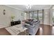 Elegant living room featuring hardwood floors, large windows, and tasteful decor at 1821 Cherry Walk Rd, Lutz, FL 33558