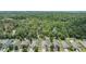 Houses in a neighborhood that share a backyard border with a dense forest with the ocean on the horizon at 18343 Waydale Loop, Hudson, FL 34667