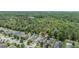 Expansive aerial view of homes backing up to a dense green forest and partial water view from distance at 18343 Waydale Loop, Hudson, FL 34667