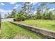 Expansive backyard with lush lawn, mature trees, and a charming stone retaining wall feature at 18343 Waydale Loop, Hudson, FL 34667