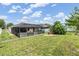 Well-maintained backyard featuring a screened-in patio, lush lawn, and partial fencing at 18343 Waydale Loop, Hudson, FL 34667