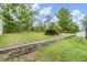 Expansive backyard with lush lawn, mature trees, and a charming stone retaining wall feature at 18343 Waydale Loop, Hudson, FL 34667