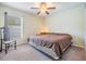 Cozy bedroom with a queen bed, ceiling fan, carpet, and a chair creating a simple and comfortable space at 18343 Waydale Loop, Hudson, FL 34667