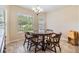 Bright dining room with a wooden table, chairs, and tile floors, illuminated by a chandelier at 18343 Waydale Loop, Hudson, FL 34667