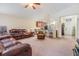 Open concept living room with plush seating, a ceiling fan, and access to the kitchen at 18343 Waydale Loop, Hudson, FL 34667
