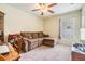Inviting living room with a cozy couch and a desk, lit by natural light and a ceiling fan at 18343 Waydale Loop, Hudson, FL 34667