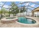Tranquil, screened-in pool and spa with brick pavers and a view of the backyard at 18343 Waydale Loop, Hudson, FL 34667