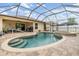 Beautiful screened-in pool and spa with brick pavers connected to an outdoor living area at 18343 Waydale Loop, Hudson, FL 34667