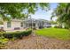 Lush backyard with a screened-in pool, patio, and fire pit area, ideal for outdoor gatherings at 204 S Trask St, Tampa, FL 33609