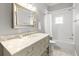 Bathroom features a marble countertop vanity with a large mirror and a shower-tub combination with white tiling at 204 S Trask St, Tampa, FL 33609