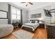 Bedroom with hardwood floors, gray walls, a bed with striped linens, and a desk by the window at 204 S Trask St, Tampa, FL 33609