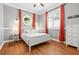 Bedroom with hardwood floors, a white bed, and red curtains framing windows with white shutters at 204 S Trask St, Tampa, FL 33609