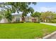 Beautifully landscaped single-story home with lush lawn, mature trees, and inviting curb appeal at 204 S Trask St, Tampa, FL 33609