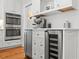 Close-up of the kitchen shows the built-in oven, a wine cooler and stainless steel espresso machine on a white countertop at 204 S Trask St, Tampa, FL 33609
