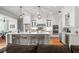 Open concept kitchen features white cabinets, stainless steel appliances, a center island and is decorated with modern hanging lights at 204 S Trask St, Tampa, FL 33609