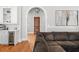 Open-concept living room showcasing hardwood floors, a large sofa, and an archway at 204 S Trask St, Tampa, FL 33609