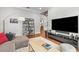 Living room with hardwood floors, gray sofa, contemporary shelving and a view into an adjacent room at 204 S Trask St, Tampa, FL 33609