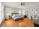 Spacious main bedroom with hardwood floors, a large bed, windows with shutters, and a ceiling fan at 204 S Trask St, Tampa, FL 33609